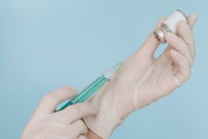 hands-with-gloves-holding-syringe-with-vaccine-bottle (1)