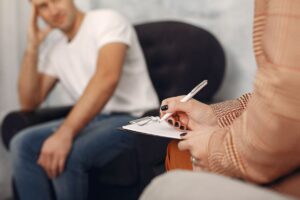man-sitting-psychologist-s-office-talking-about-problems (1)