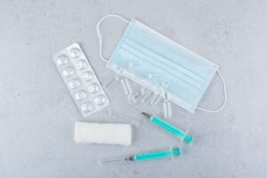 mask-ampoules-syringes-medical-pills-marble-background-high-quality-photo (1)
